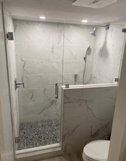 Shower enclosure with marble walls and glass door