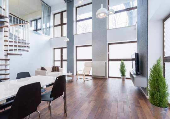 white table with black chairs and large windows that go up to the ceiling